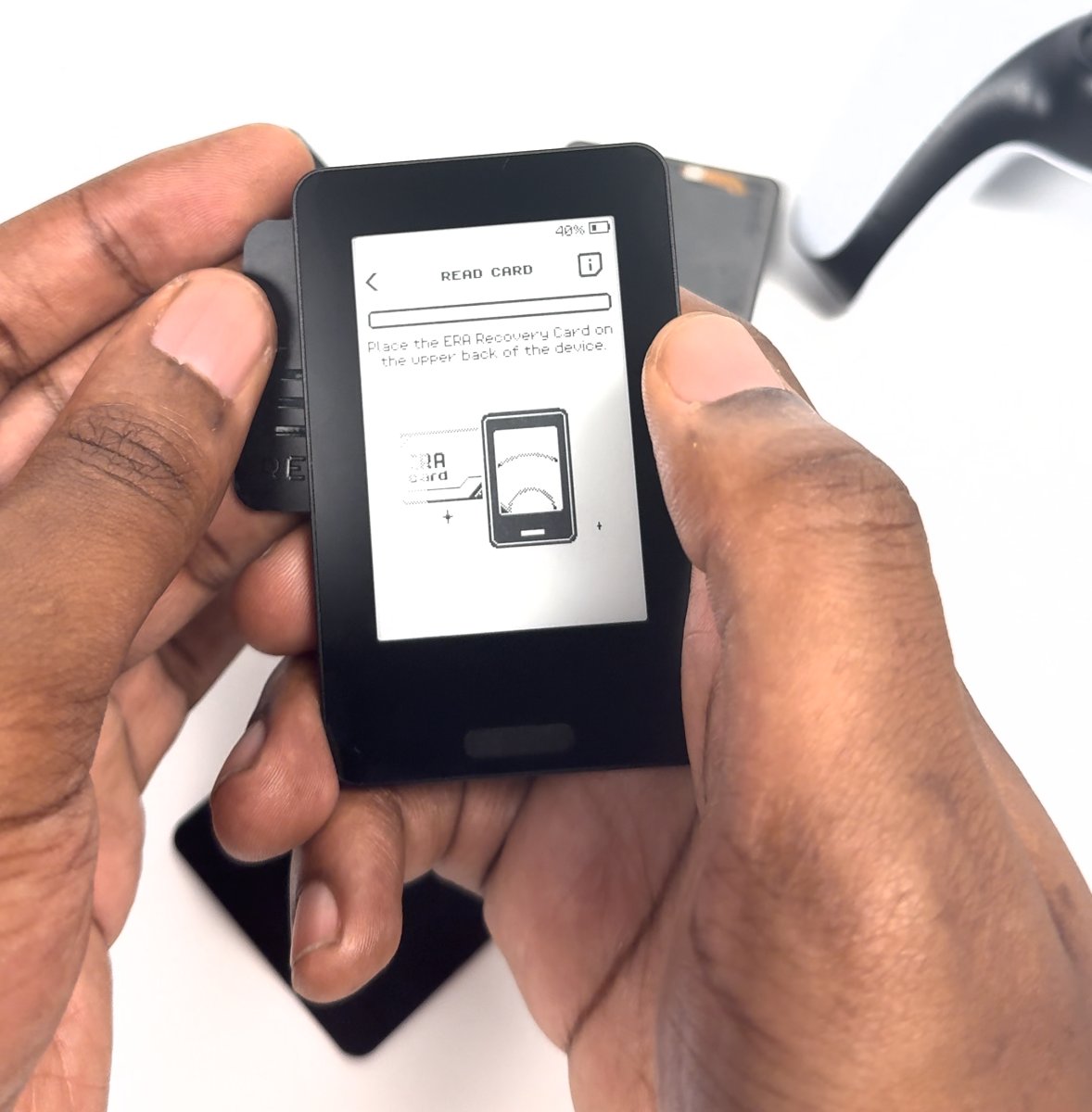 ERA Recovery Card held behind the upper half of the device while the screen reads READ CARD, place the card on the upper back