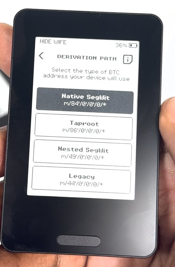 Device photo: DERIVATION PATH screen listing Native SegWit (selected), Taproot, Nested SegWit and Legacy.